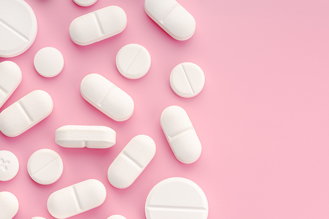 Witte tabletten met roze achtergrond