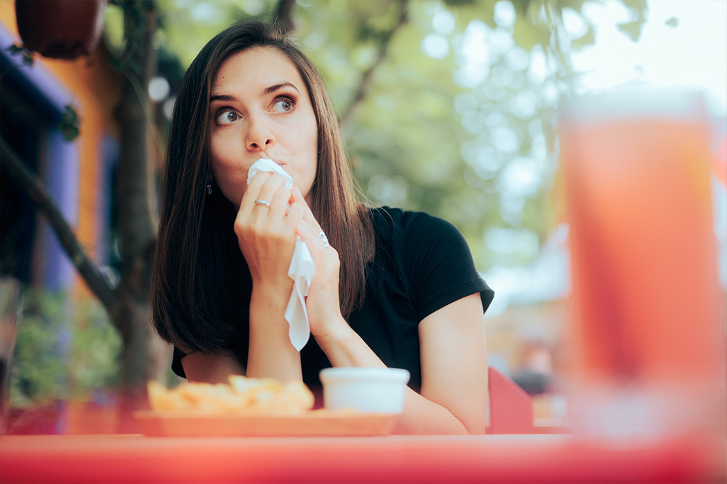 Vrouw veegt haar mond af na een maaltijd