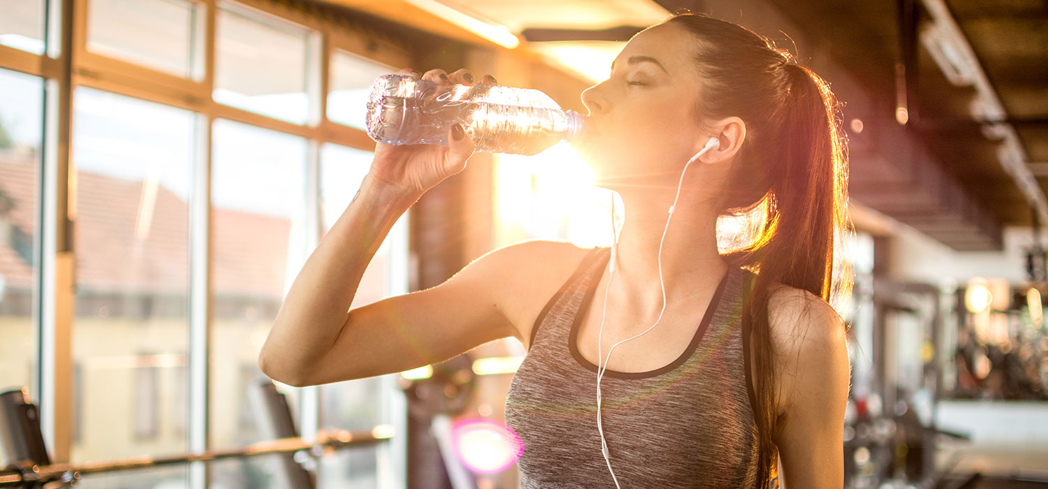 Vrouw drinkt water na het sporten